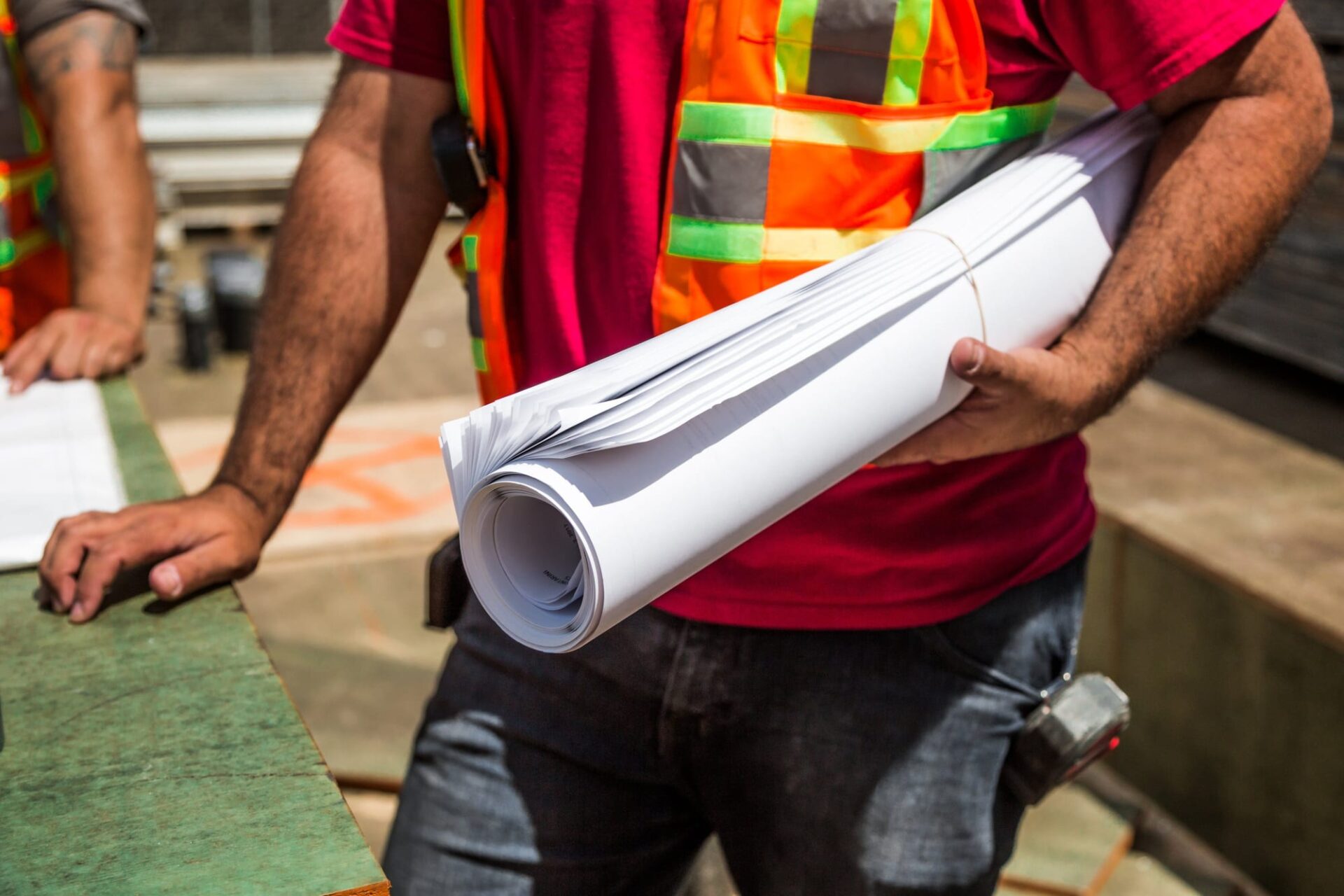AMP Construction worker with building plans on site